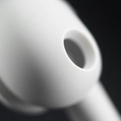 Extreme close-up of one earbud showing the speaker opening and the matte finish — Macro Detail style, generated by ListIQ Pro